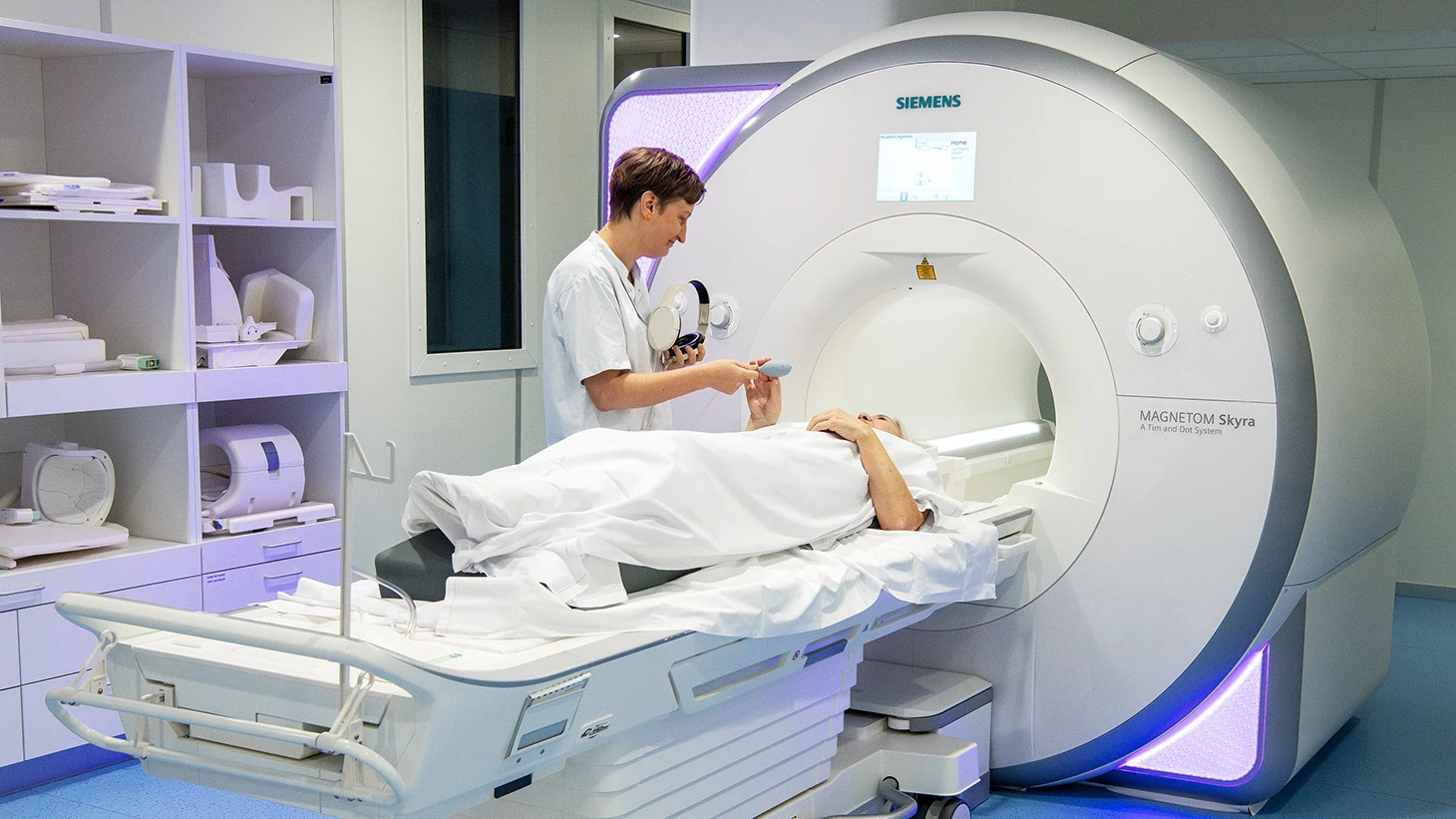 Patient på leje i MR-skanner med medarbejder ved siden af