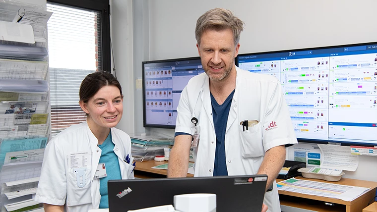Flere forskellige faggrupper samarbejder om at udrede patienten og skræddersy en behandlingsplan. På billedet ses en yngre læge og en overlæge konferere om en patient.