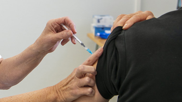 Sundhedsperson vaccinerer borger mod covid-19.