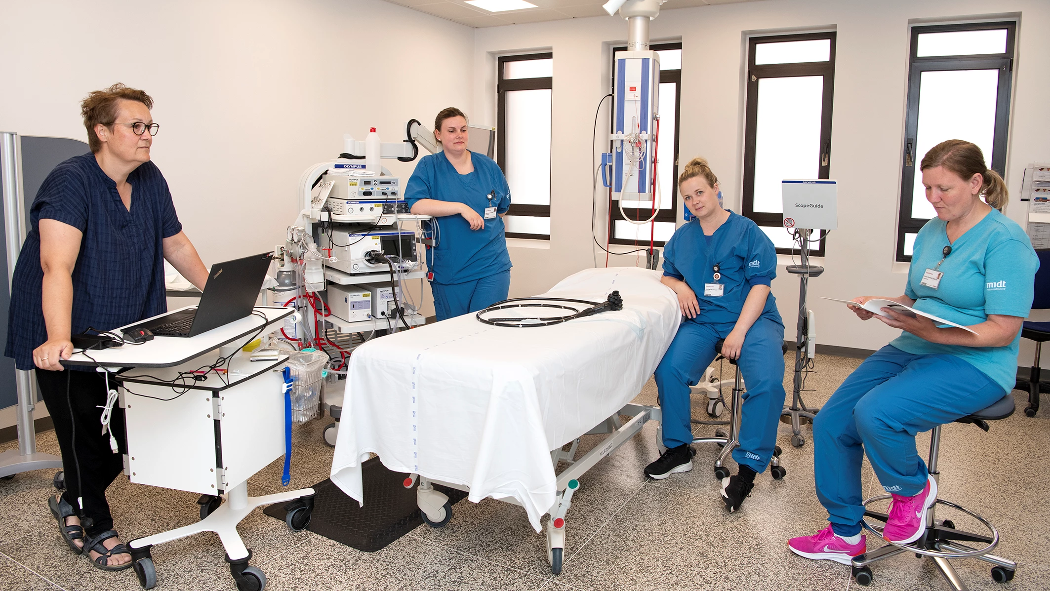Et hold bestående af 4 medarbejdere står klar på stuen  til at foretage en kikkertundersøgelse, men patienten mangler.