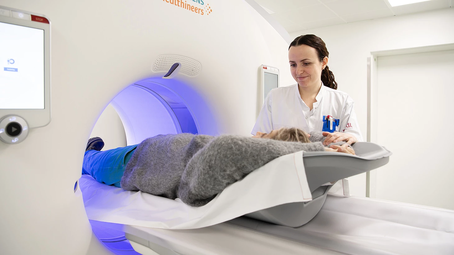 Medarbejder i dialog med patient, der ligger i ct-skanner